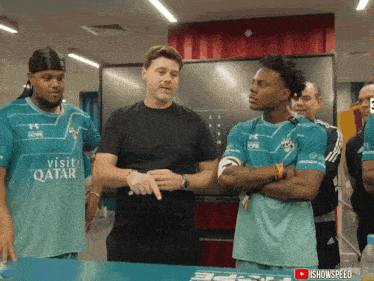 a man wearing a shirt that says visit qatar is talking to two other men