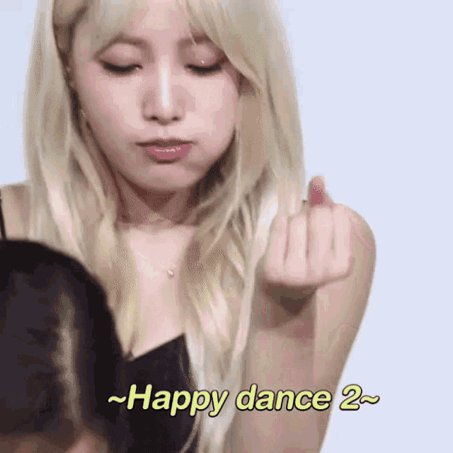 a woman with blonde hair is making a middle finger gesture with the words happy dance 2 below her .