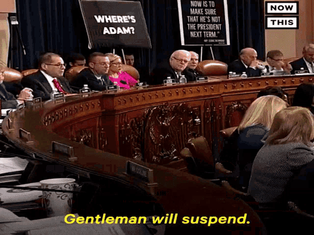 a group of people sitting in a room with a sign that says where 's adam