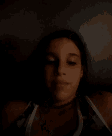 a girl is waving her hand in the dark .