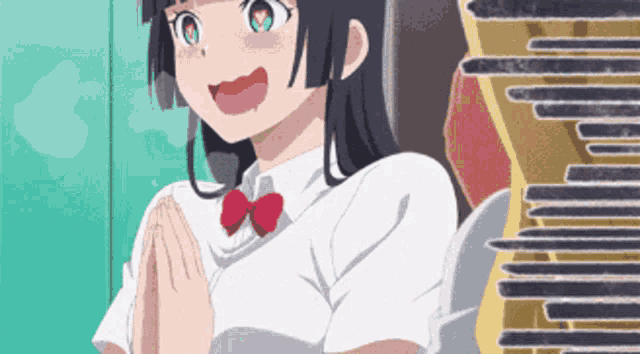 a girl in a white shirt and red bow tie is smiling with her hands folded