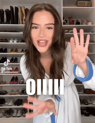 a woman is standing in front of a closet and says oiiii on the bottom of her face