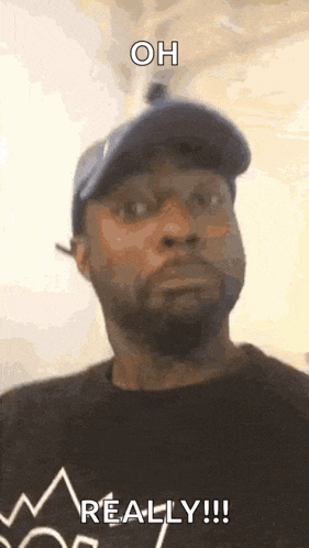 a man wearing a hat and a black shirt is making a funny face and saying `` oh really ! ''