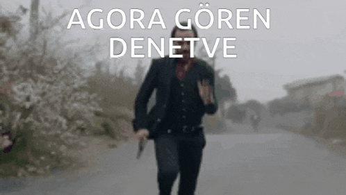 a man in a suit and vest is running down a street with the words agora goren denetve above him