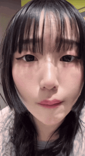 a close up of a girl 's face with a gray shirt on