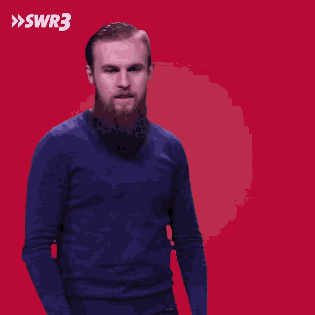 a man in a blue shirt is pointing at the camera with the swr3 logo in the corner
