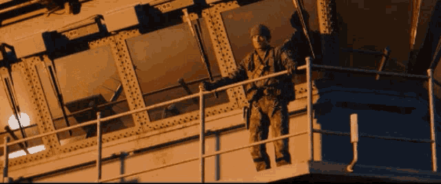 a man in a military uniform stands on top of a railing