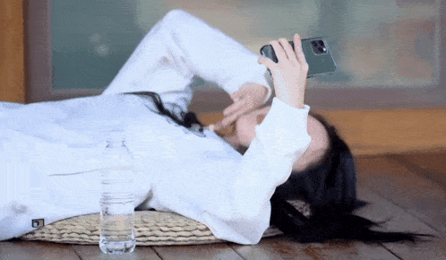 a woman laying on the floor with a bottle of water