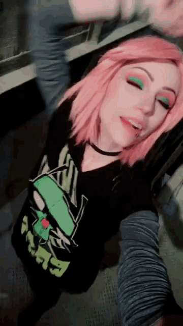 a woman with pink hair is wearing a t-shirt that says ' looney tunes ' on the front