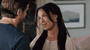 a man and woman are looking at each other and the woman is wearing earrings