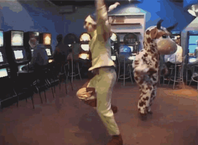 a giraffe and a clown are dancing in an arcade room