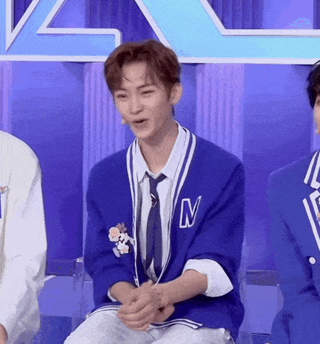a man in a blue jacket and tie with the letter n on it