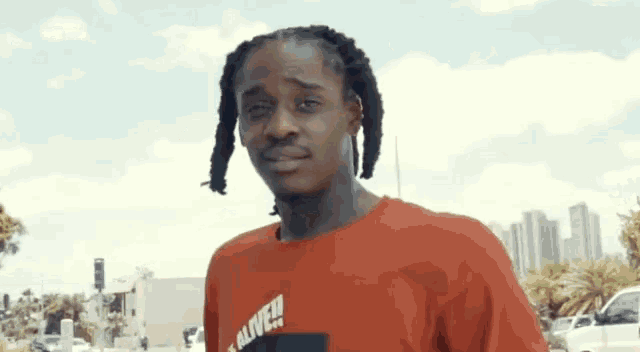 a man wearing a red t-shirt that says alive on it