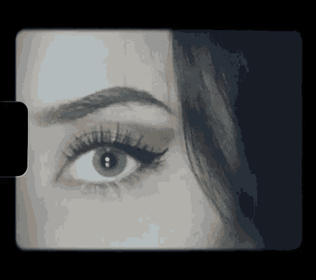 a close up of a woman 's eye with a black background