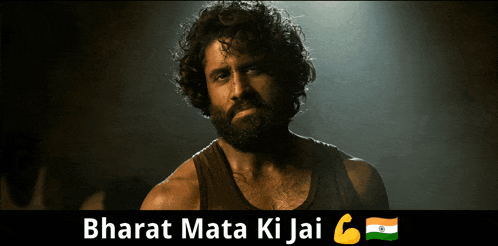 a man with curly hair and a beard stands in front of a sign that says bharat mata ki jai