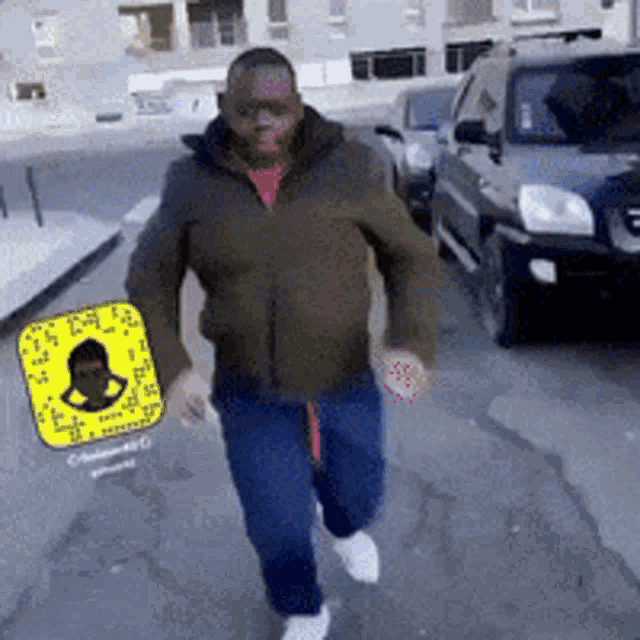 a man in a green jacket is walking down a street