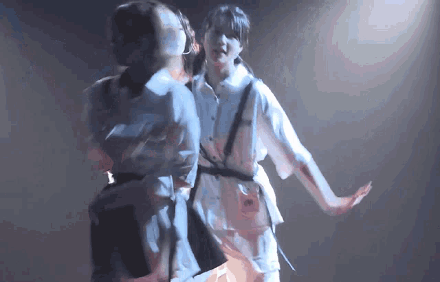 two women are dancing on a stage and one of them has a badge that says ' a ' on it