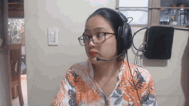 a woman wearing glasses and headphones with a microphone on her head