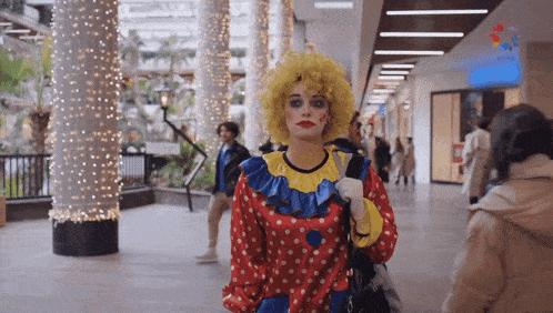 a woman in a clown costume stands in a shopping mall
