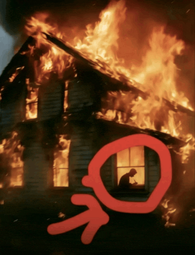 a man sits in a window of a burning house with a red arrow pointing to it