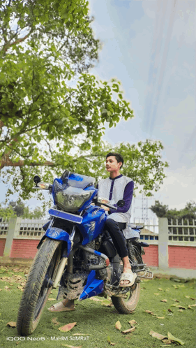 a man is sitting on a blue motorcycle with a yamaha logo on the front