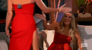 two women in red dresses are standing next to each other and laughing .