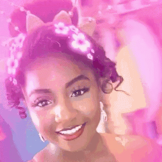 a woman wearing a cat ear headband with flowers in her hair .