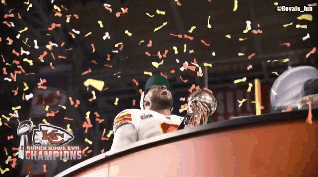 a man holding a super bowl trophy with confetti falling around him