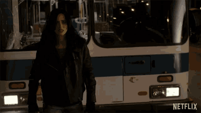 a woman stands in front of a bus that says i did on it