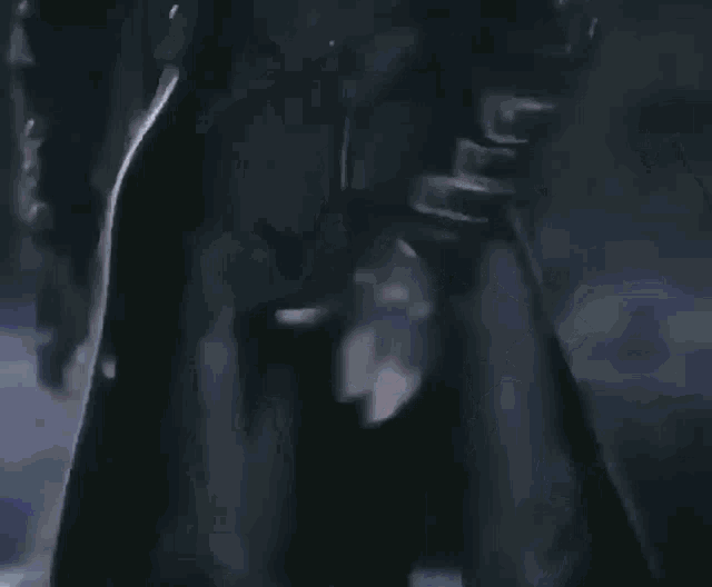 a man in a black jacket with a x on the sleeve