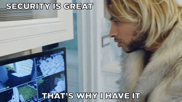 a man in a fur coat is looking at a monitor with the words security is great that 's why i have it