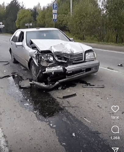 a car that has been damaged in a crash is on the side of the road