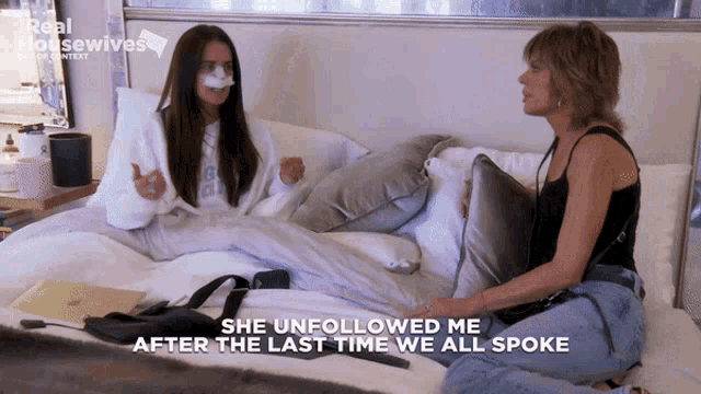 two women are sitting on a bed with the words she unfollowed me after the last time we all spoke on the bottom