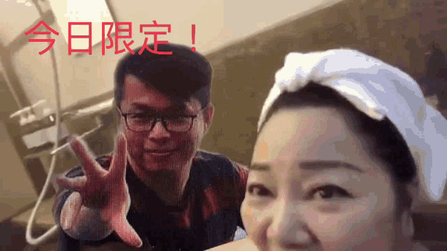 a man with glasses and a woman with a towel on her head are standing next to each other
