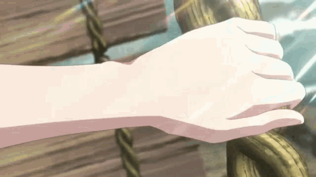 a close up of a person 's hand against a wooden fence .