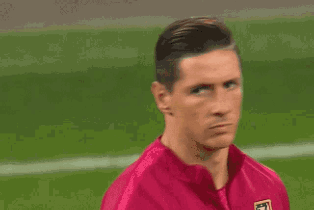 a soccer player wearing a pink shirt with a badge that says ' atlético madrid ' on it
