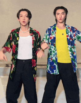 two young men wearing hawaiian shirts are dancing