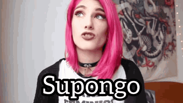 a woman with pink hair is wearing a black shirt with the word supongo on it