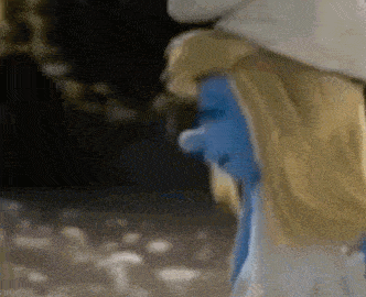 a close up of a smurf wearing a white hat and a blue face .