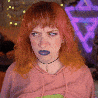 a woman with red hair and blue lipstick makes a funny face