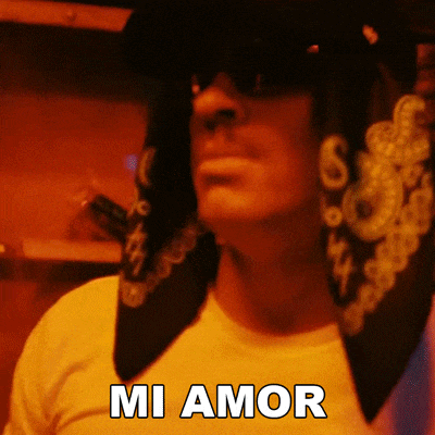 a man wearing sunglasses and a bandana has the word mi amor written on his shirt