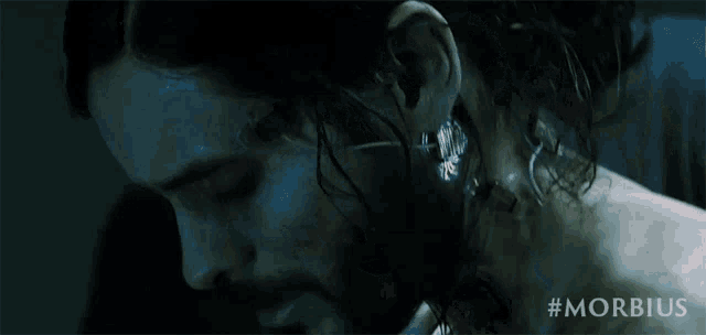 a close up of a man 's face and a woman 's face in a dark room .