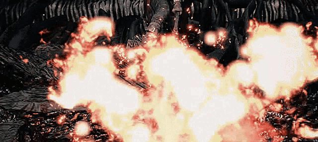a person is holding a sword in front of a large fire .