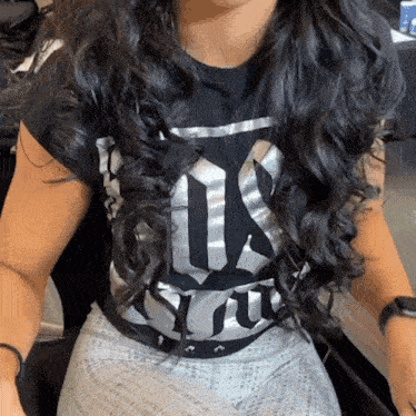 a woman is wearing a black shirt that says us on it
