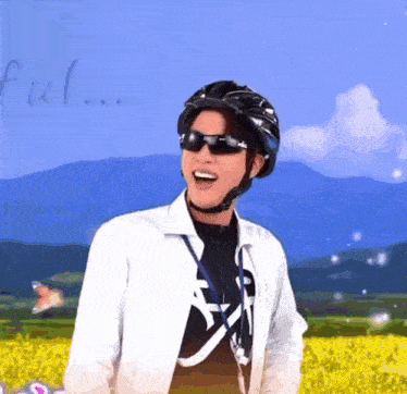 a man wearing a helmet and sunglasses is standing in front of a field of yellow flowers
