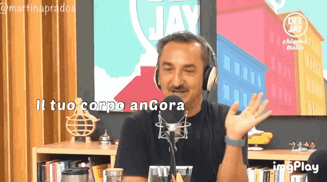 a man wearing headphones stands in front of a microphone with the words il tuo corpo ancora written below him