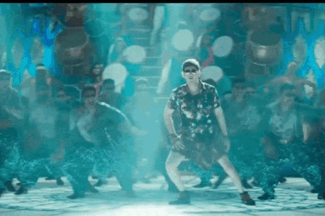 a man is dancing in front of a crowd of people with drums .