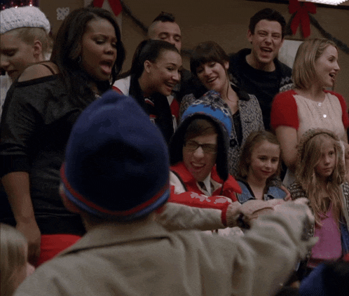 a group of people are gathered in a room and one of them is wearing a jacket that says ' abercrombie '