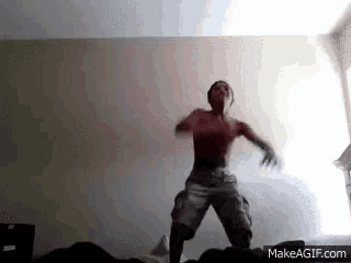 a man without a shirt is jumping in the air in a room .