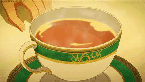 a cup of tea with a green and gold rim and saucer
